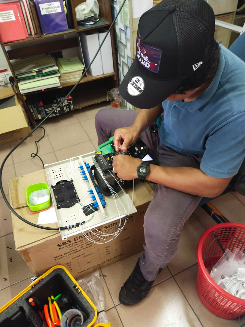 Network engineer managing Ethernet and fiber optic cables inside a server rack in a data center