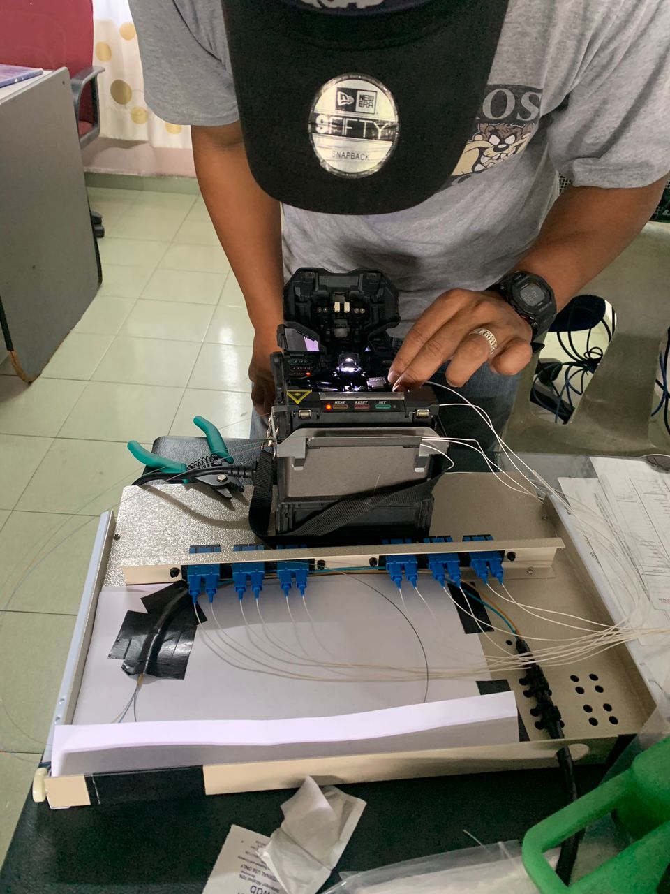 Technician performing fiber optic splicing using a fusion splicer machine